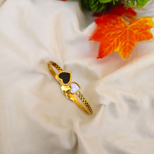 Dainty gold-tone heart charm bracelet on a delicate link chain, minimalist jewelry style.