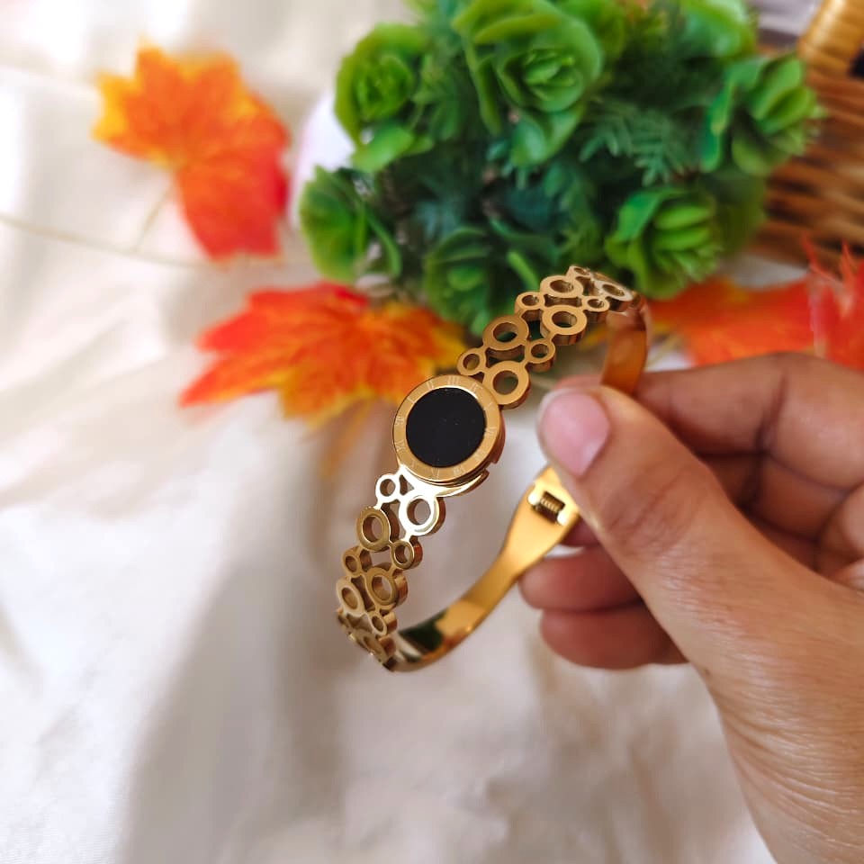 Minimalist gold-tone circle bracelet with a polished open-circle charm on a delicate chain.