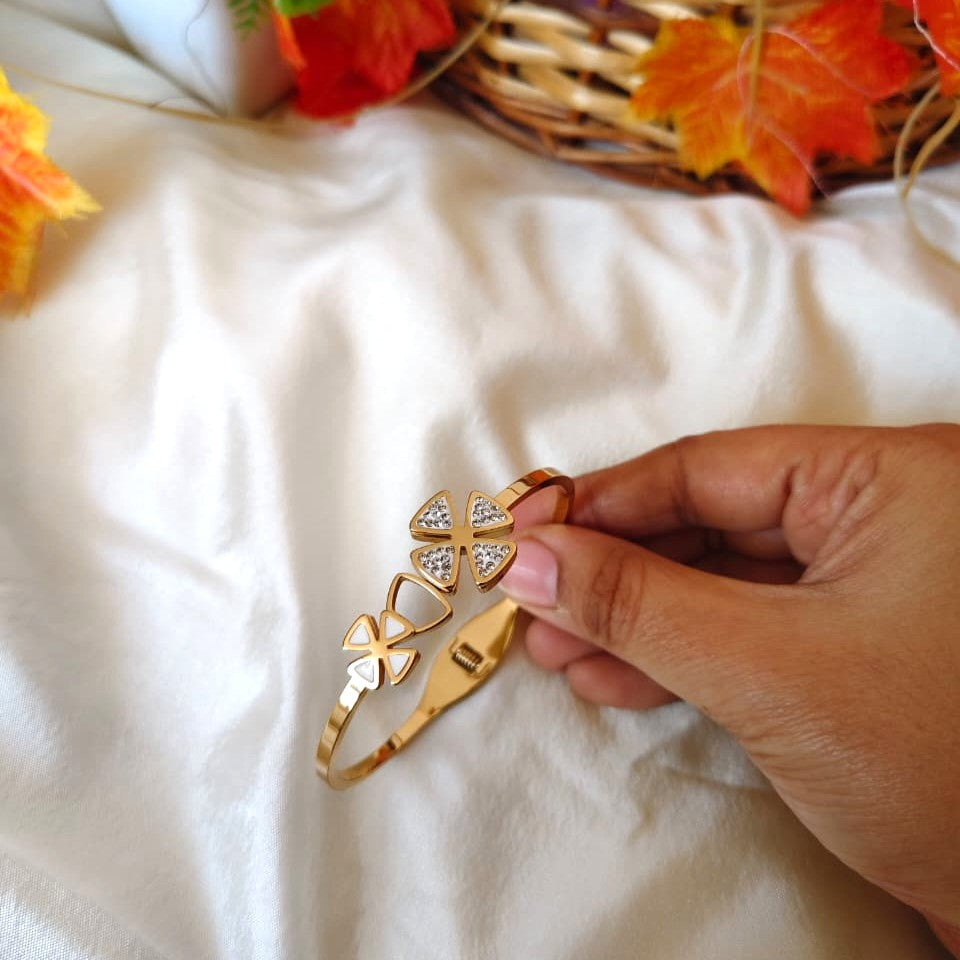 Polished gold bracelet with a modern minimalist design, captured in natural lighting.
