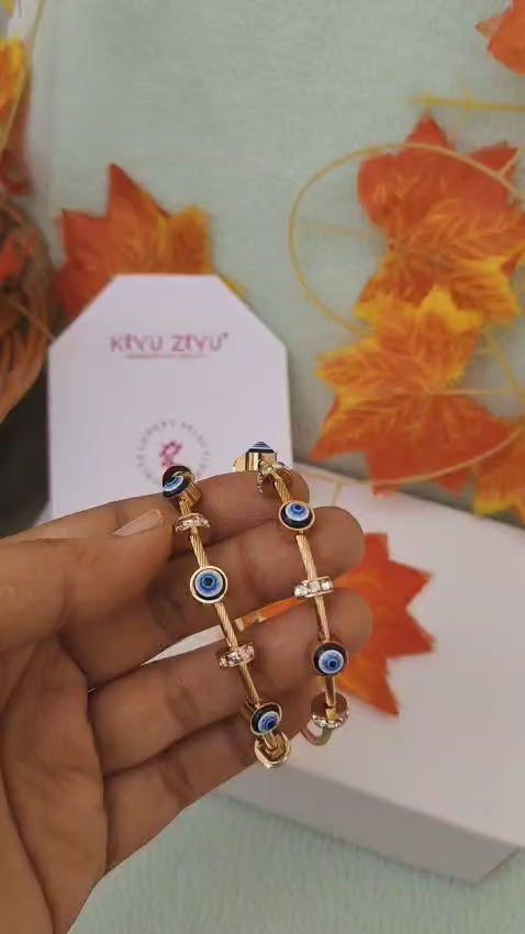 Modern eye design bracelet with centered iris detail and gold-tone finish.